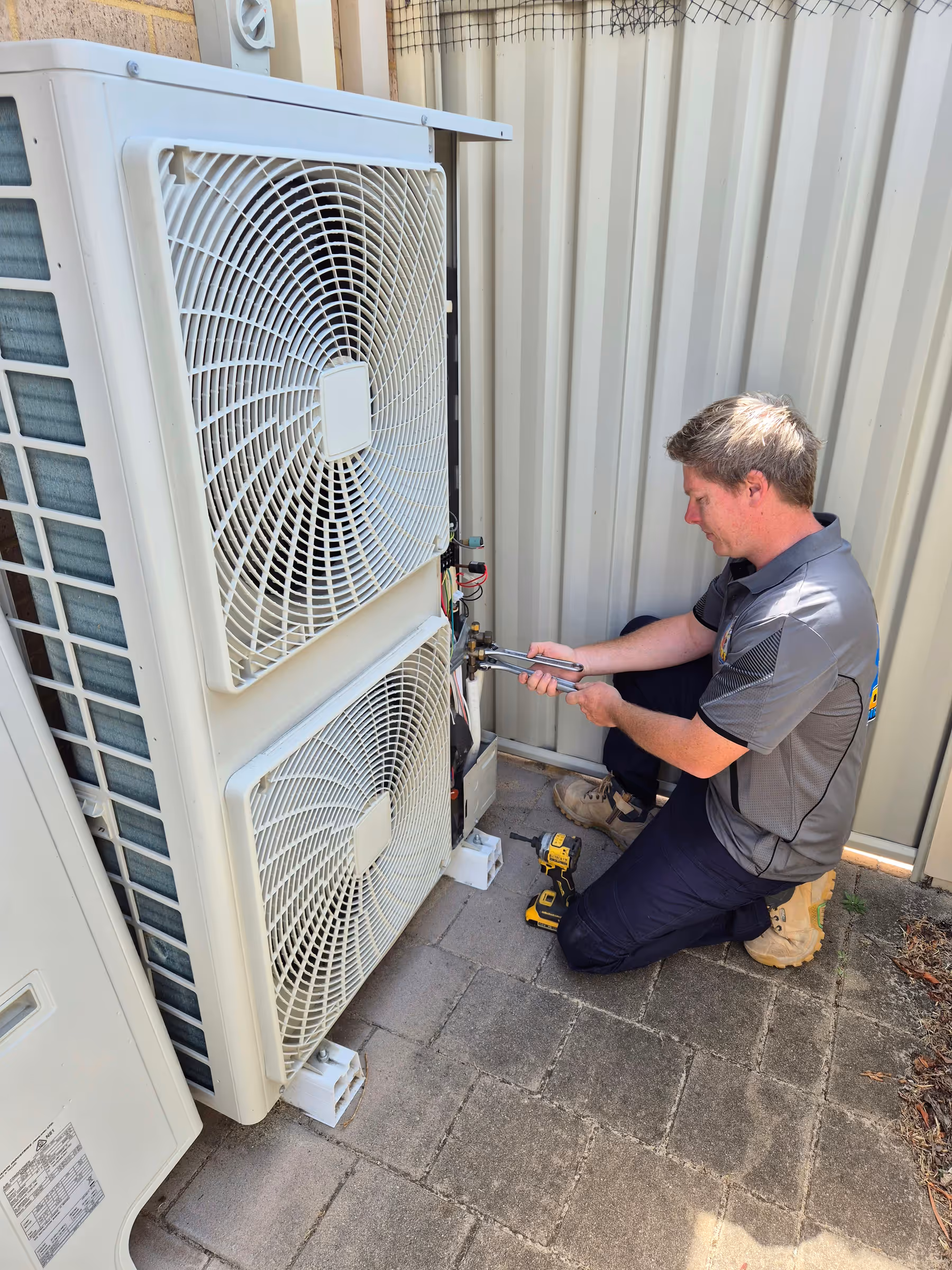 Technician repairing an outdoor air conditioning unit
