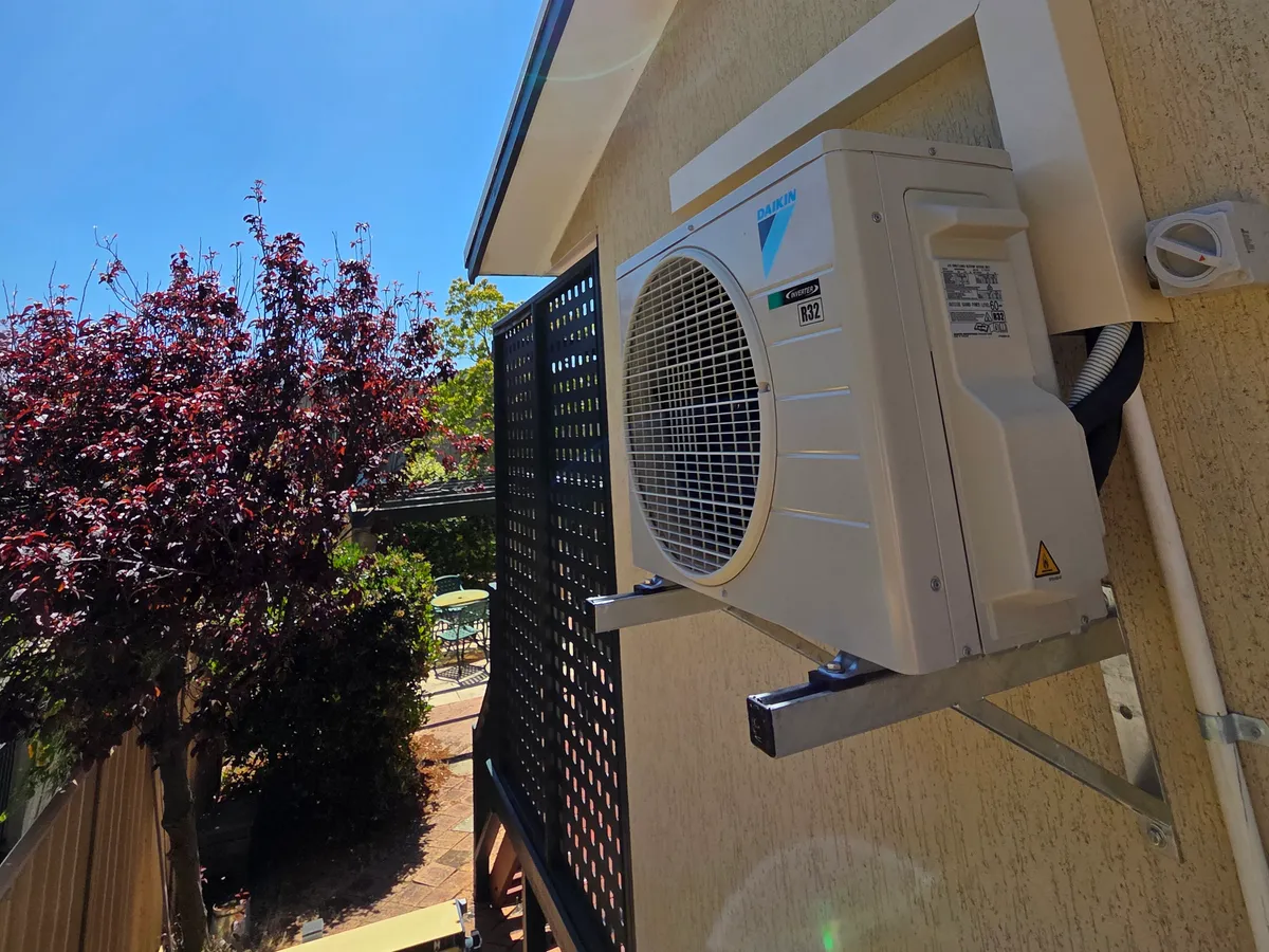 Daikin split system outdoor unit installed under the eaves of a Perth home by Otter Air